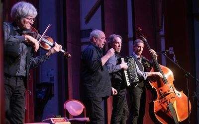 Auf der Bühne der Alten Turnhalle musiziert das Ensemble JONTEF. Vier Männer mit Violine, Gesang, Akkordeon und Kontrabass.