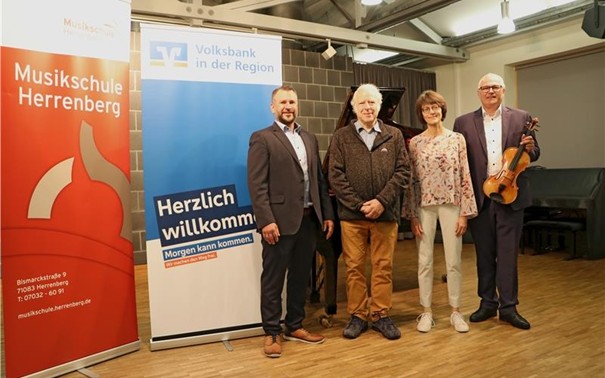 Im Studio der Musikschule sind vier Vertreter*Innen der Volksbank in der Region, der Musikschule und des Förderkreises der Musikschule neben den Bannern der Musikschule und der Volksbank.